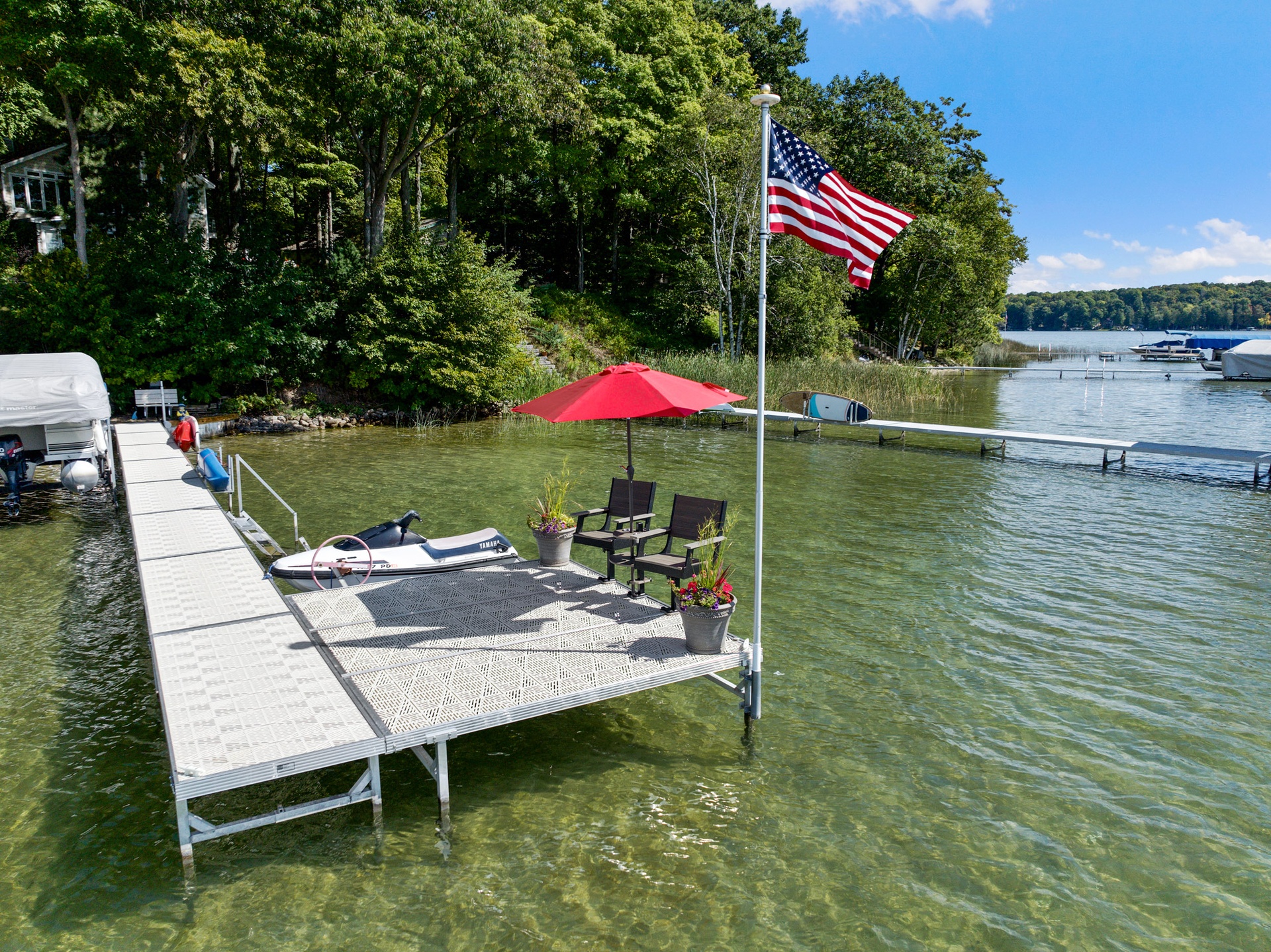Twin Bay dock with seating, table, umbrella, and waterfront accessories